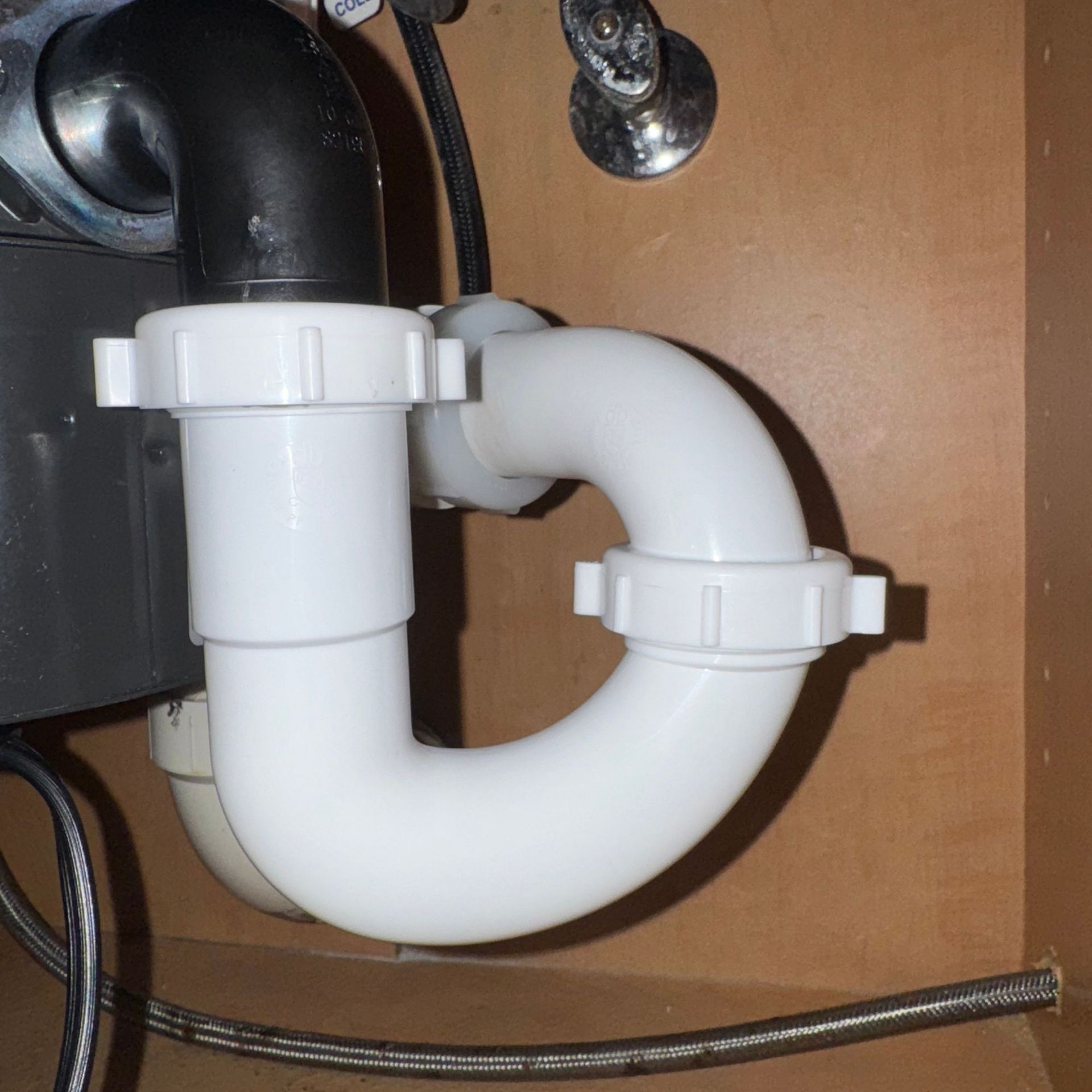 Tarpon Plumbing & Drains - A white pipe is connected to a black pipe under a sink