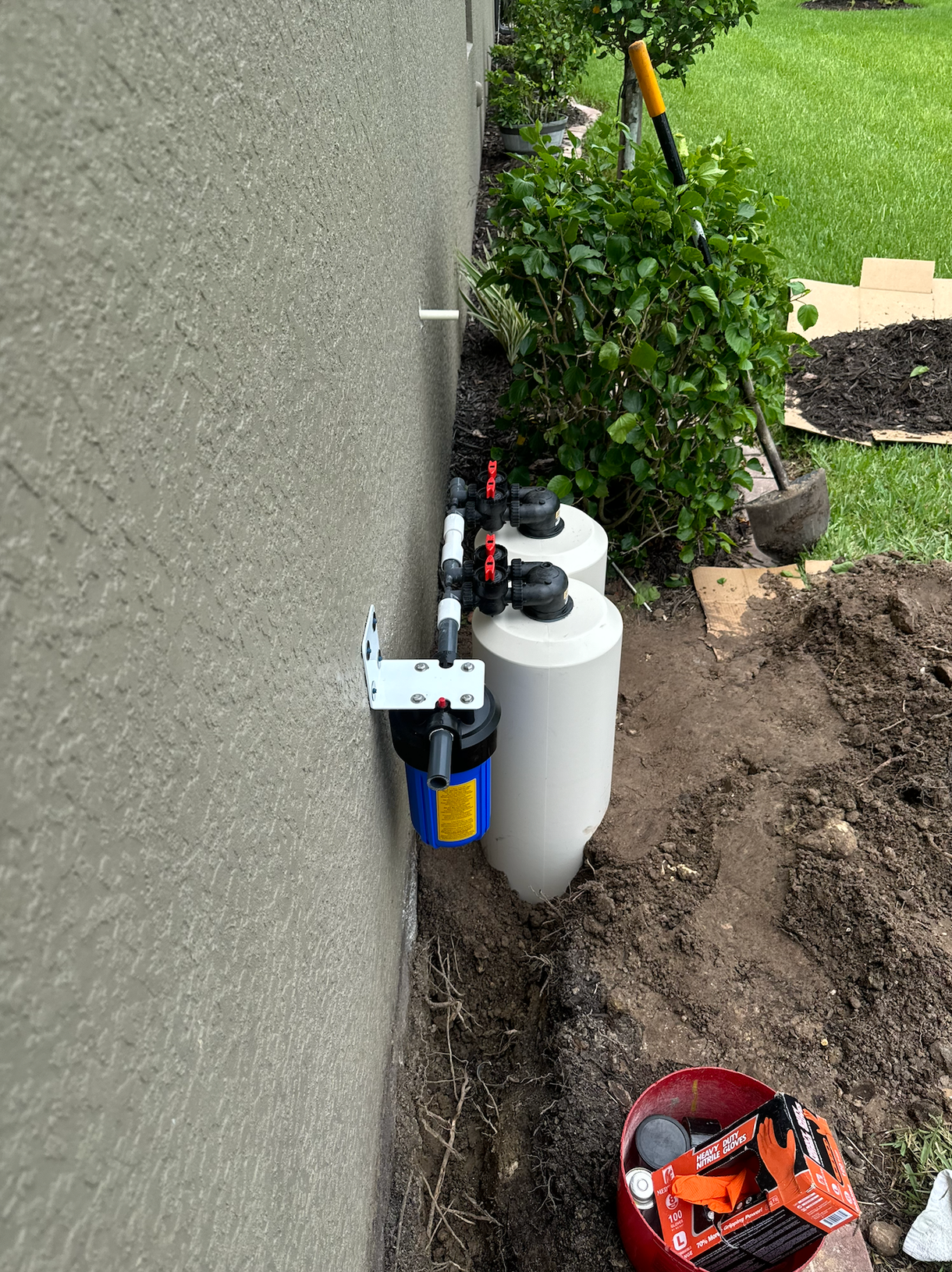 A water filter is being installed on the side of a house.