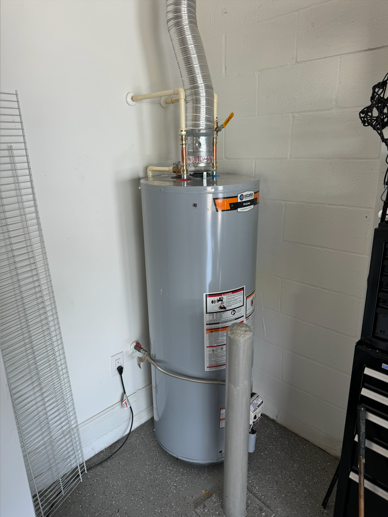 Tarpon Plumbing & Drains - A water heater is sitting in a room next to a wall.