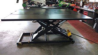 A black table is sitting on top of a concrete floor in a garage.