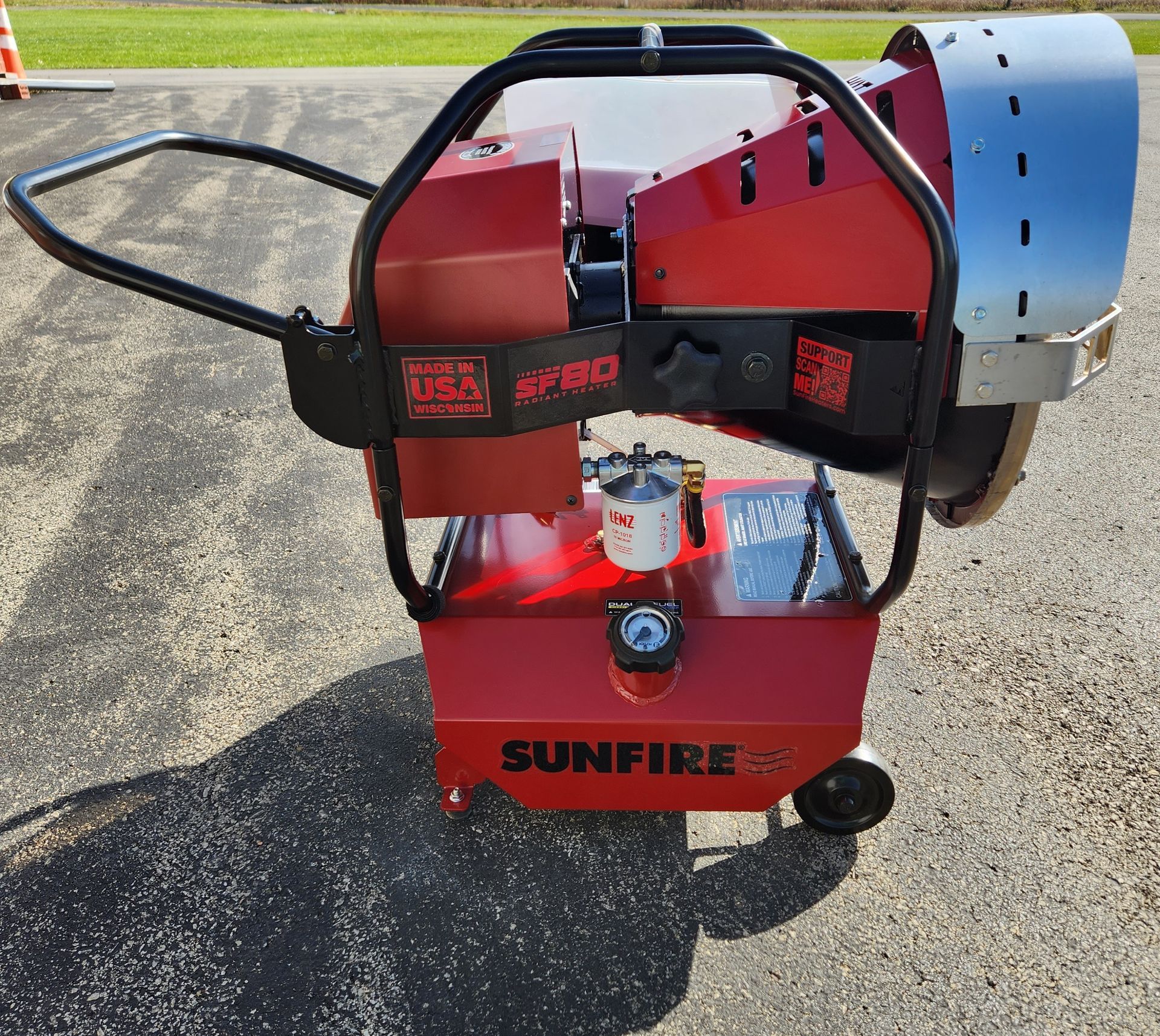 A red sunfire heater is sitting on the ground
