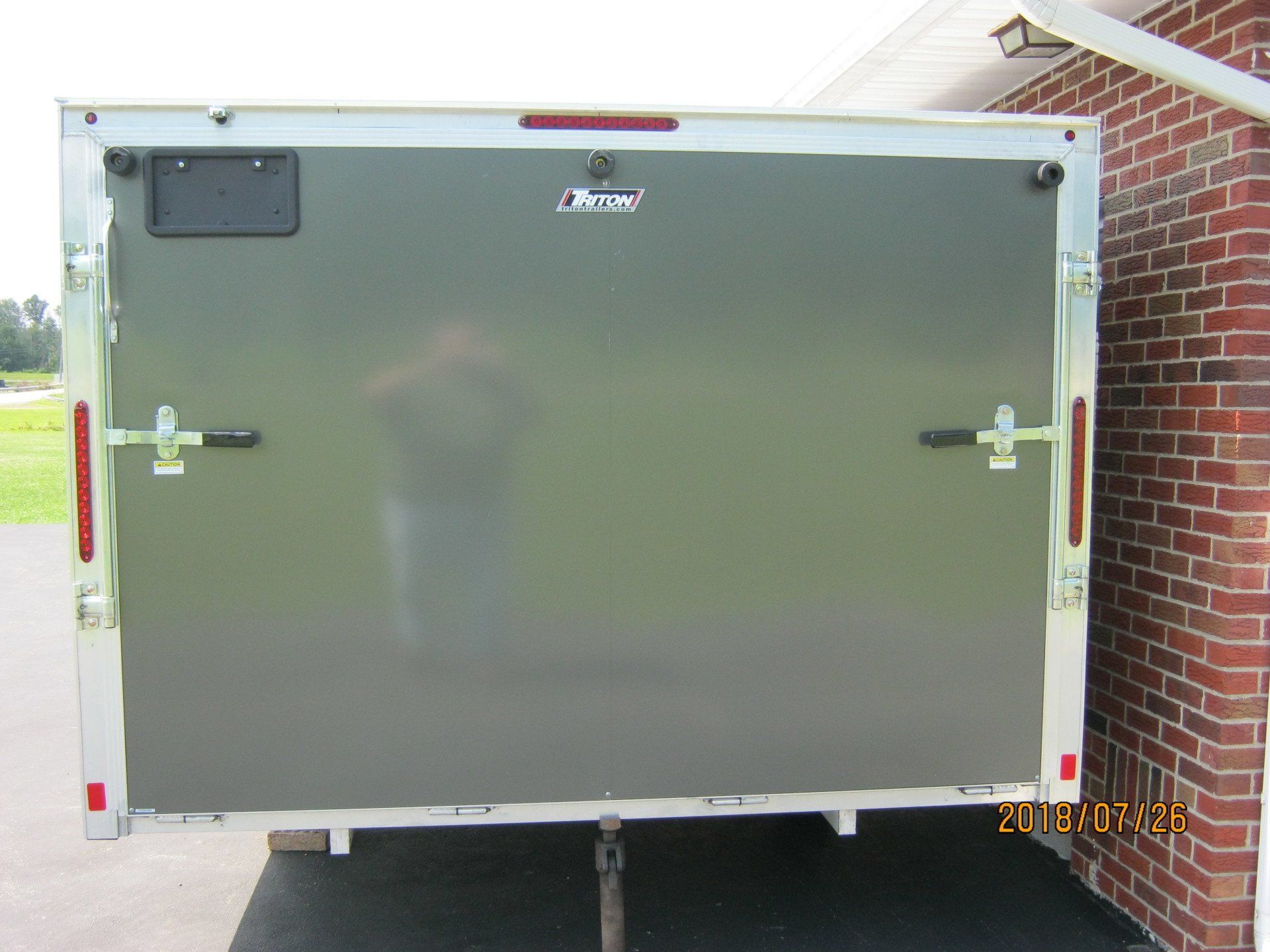 A trailer is parked in front of a brick building