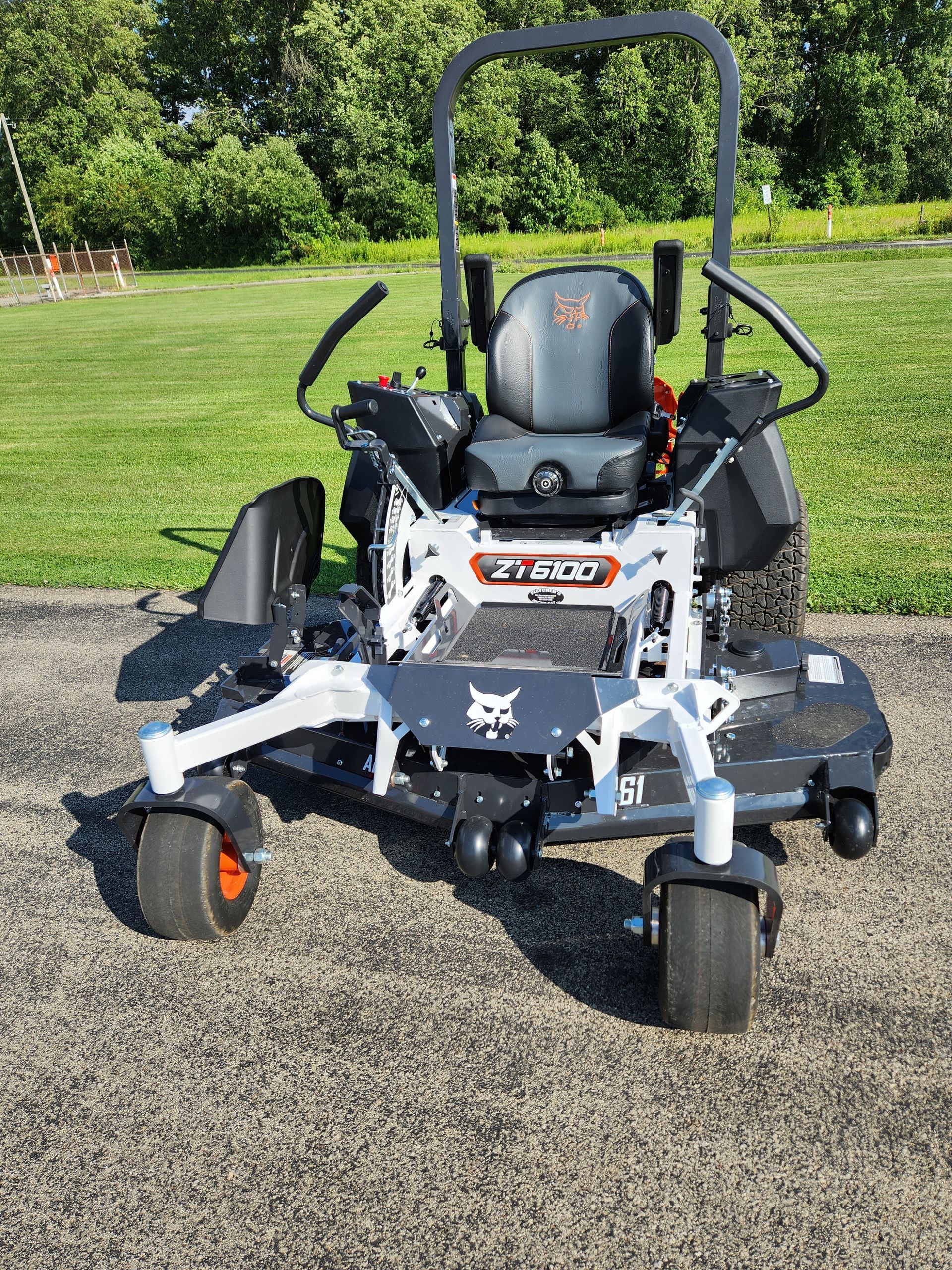A bobcat zero turn lawn mower is parked on the side of the road.