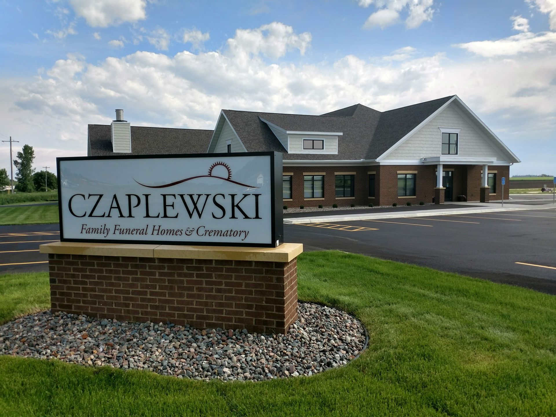 Sunset over a wildflower meadow, sunbeams through a lone tree, blue sky.