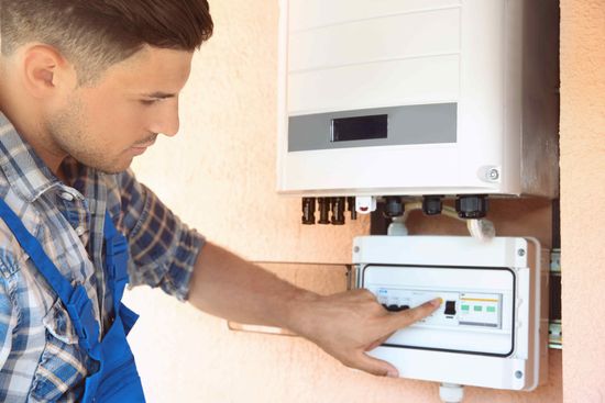 Affordable Solar Worker Installing Solar Electrical Panel On Side Of House