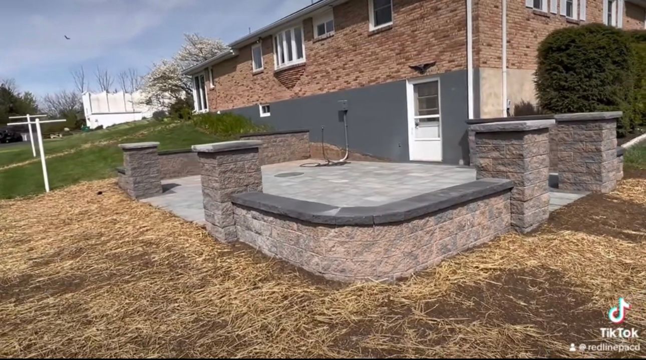 A brick house with a patio in front of it.