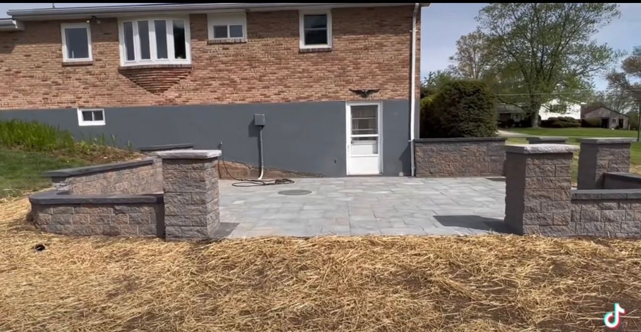 A brick house with a patio in front of it.