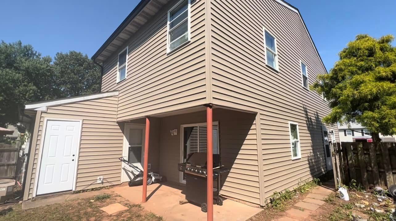 The back of a house with a porch and a garage.
