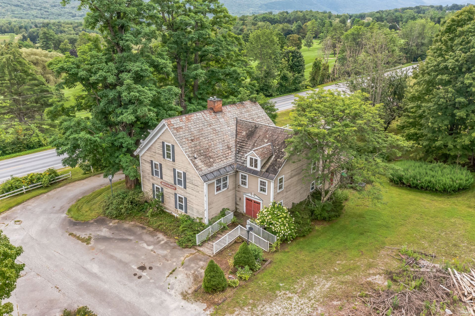 an aerial view of a large house surrounded by trees and grass .