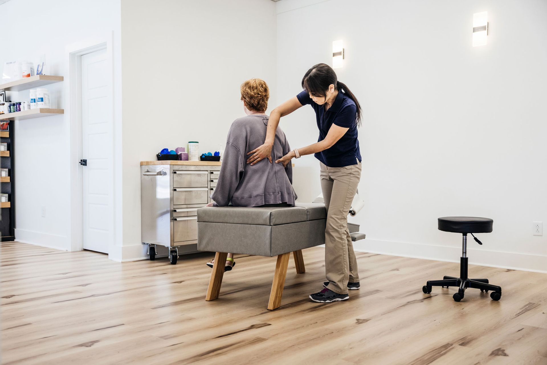 A chiropractor is examining a woman’s back. A chiropractor is examining a woman’s back.