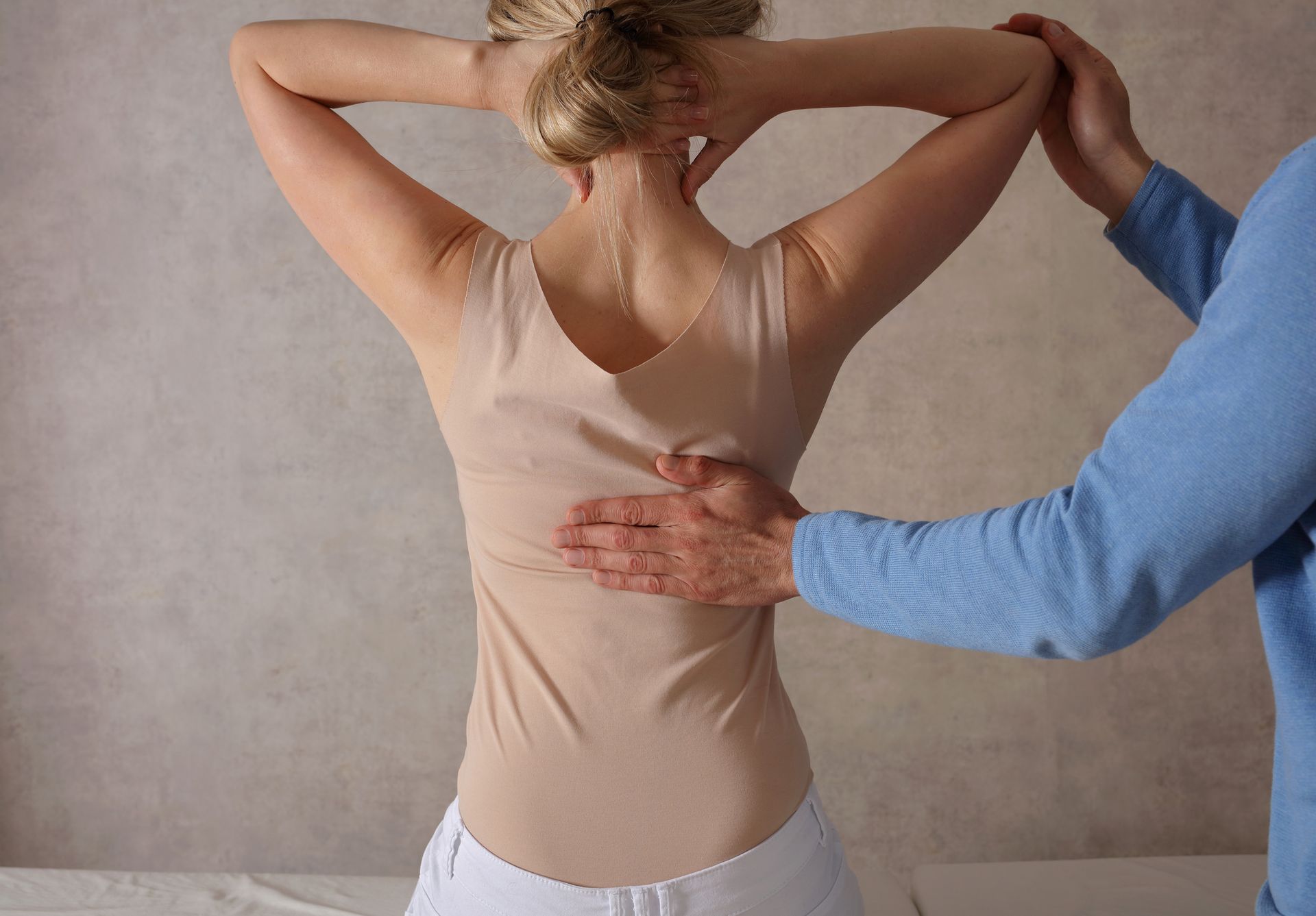 Woman receiving chiropractic therapy for back pain from professional chiropractor.