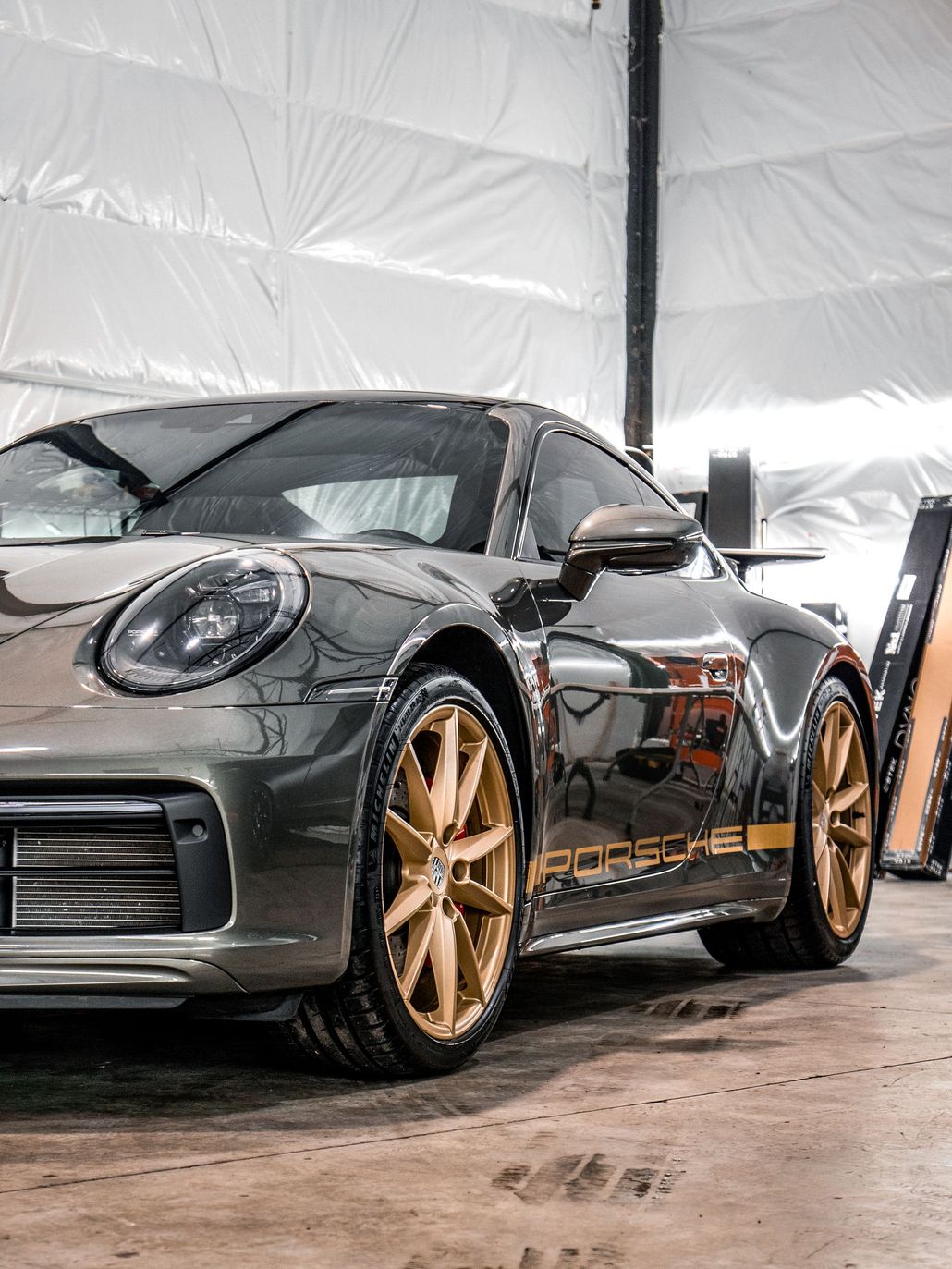 a black and gold porsche 911 is parked in a garage .