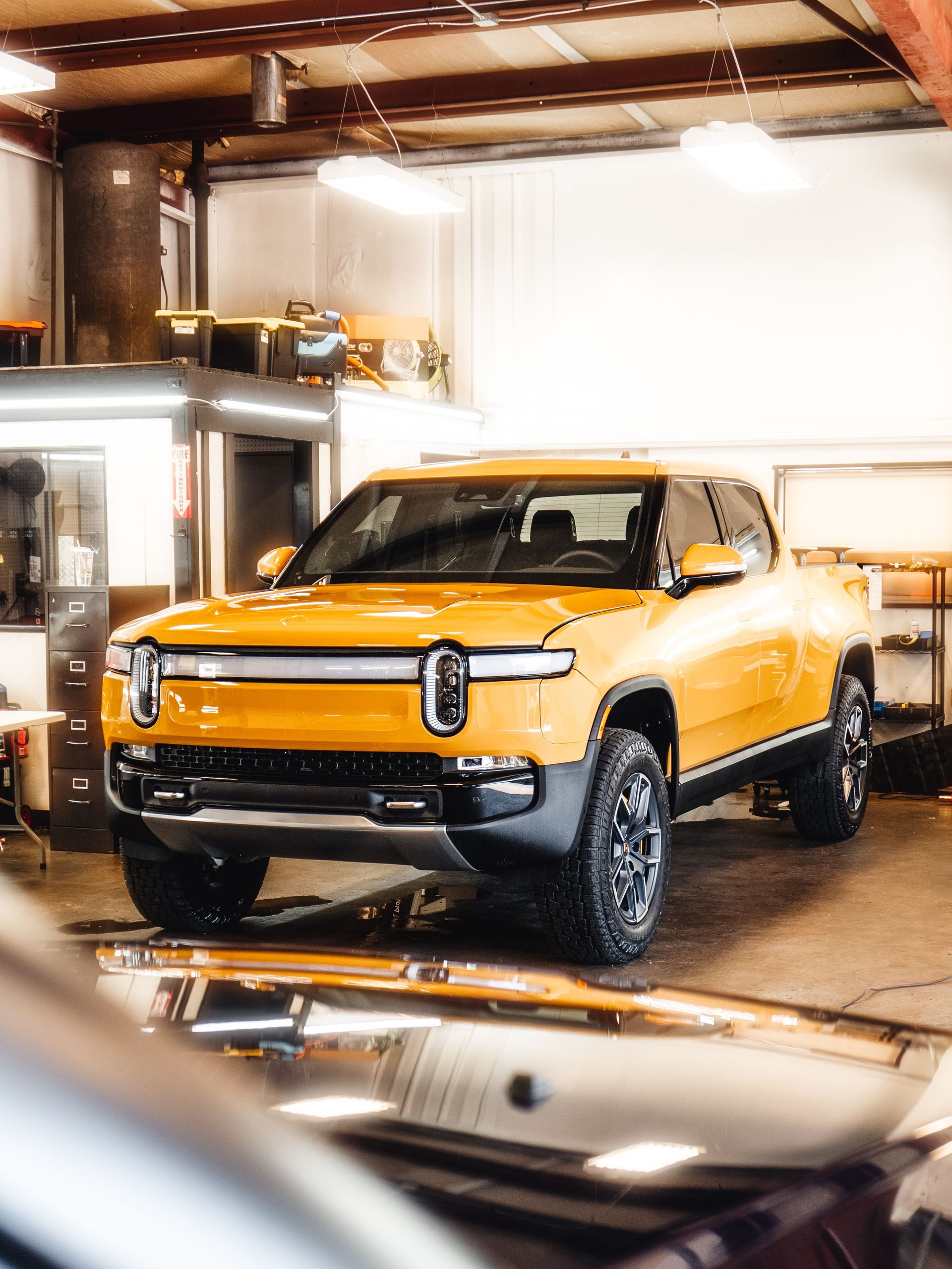 a yellow suv is parked in a garage .