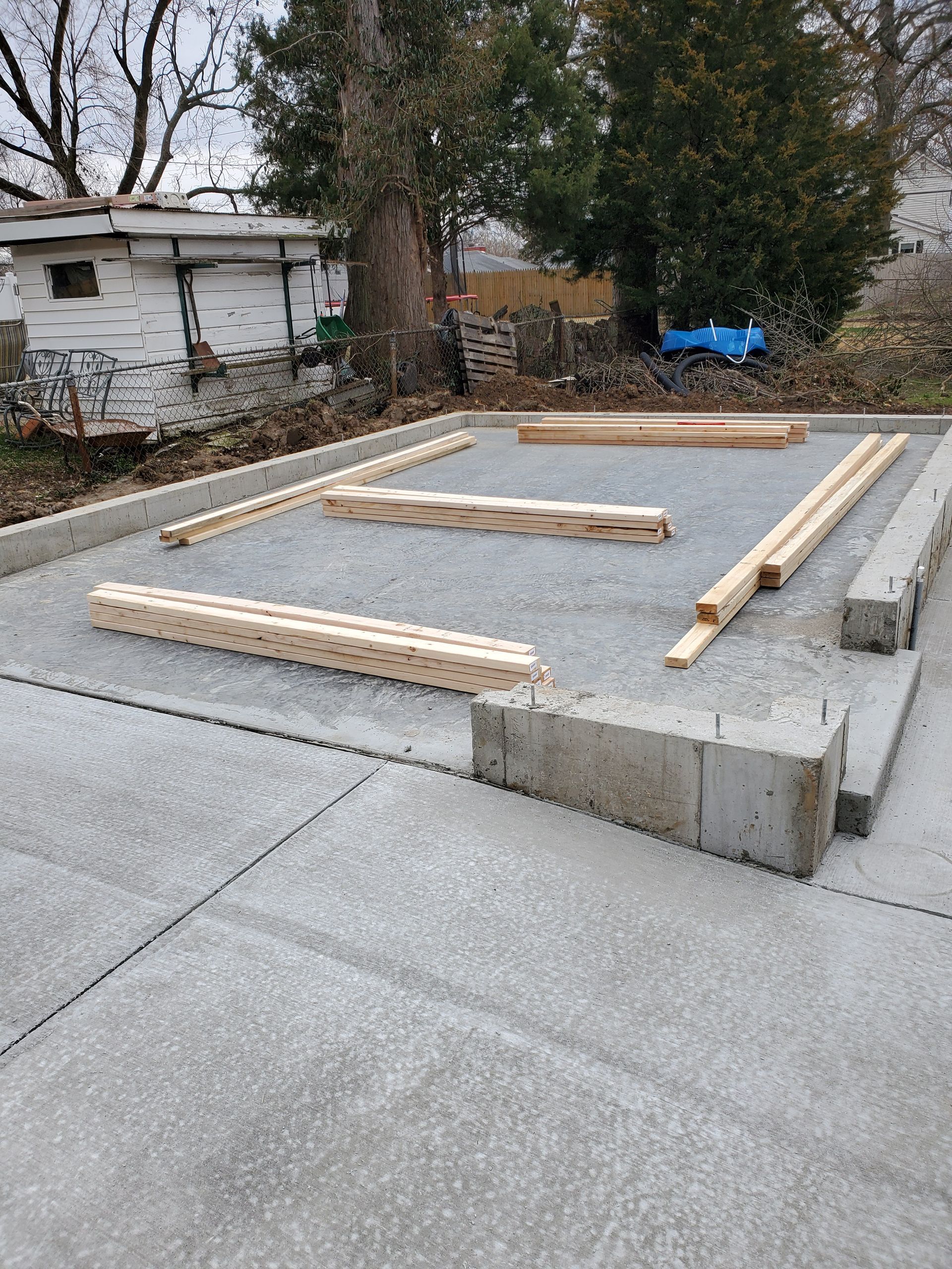 Concrete foundation with wooden beams laid out for construction.
