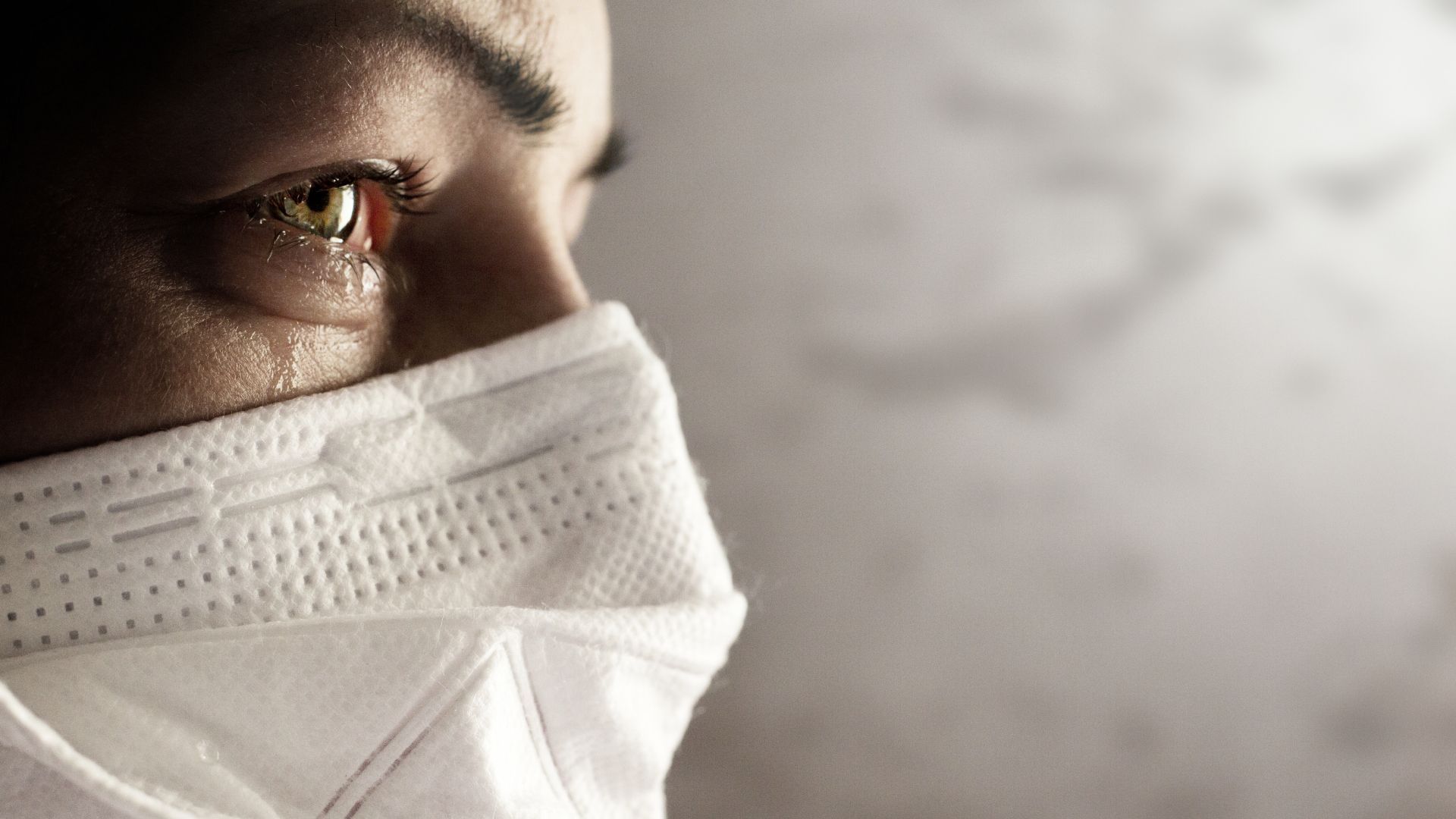 A close up of a person wearing a face mask.