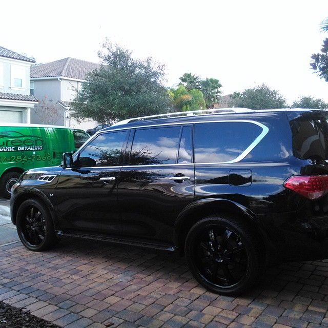 A black suv is parked on a brick driveway