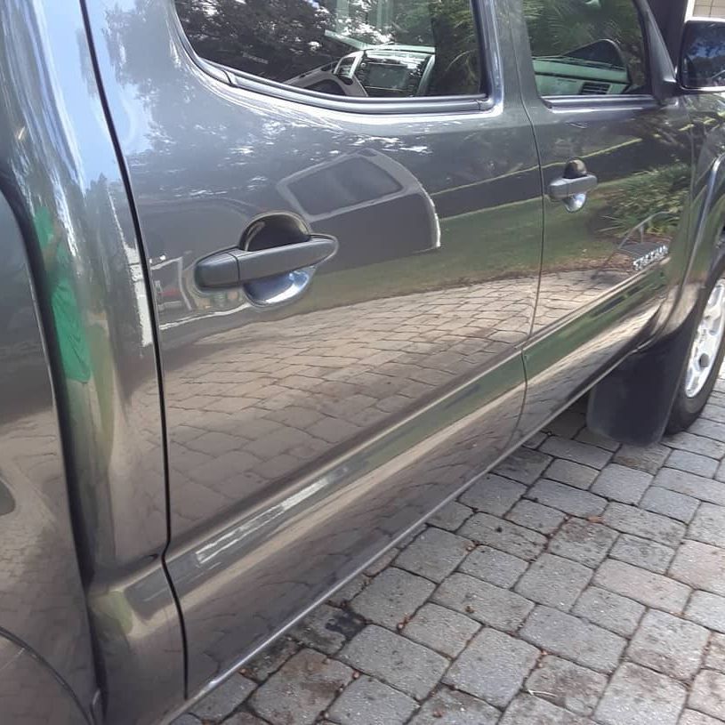 A gray truck is parked on a brick driveway