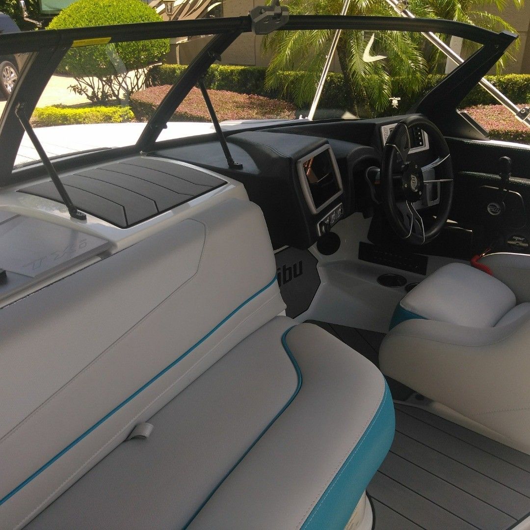 The inside of a boat with a steering wheel and seats