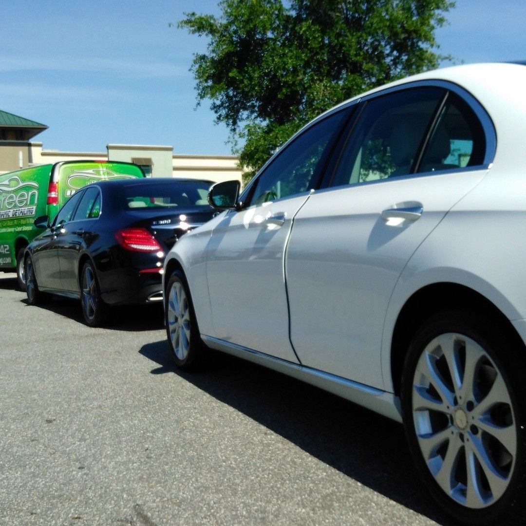 A white car is parked next to a black car