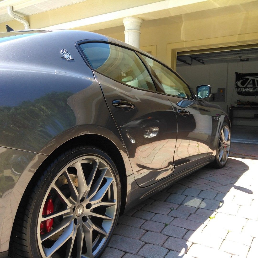 A black car is parked in front of a garage