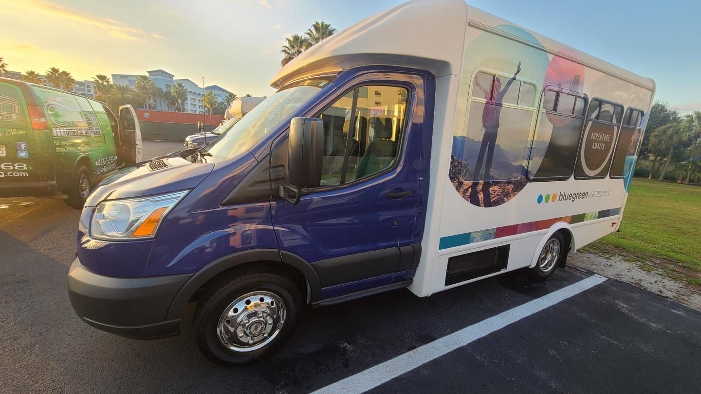 A blue and white van is parked in a parking lot.