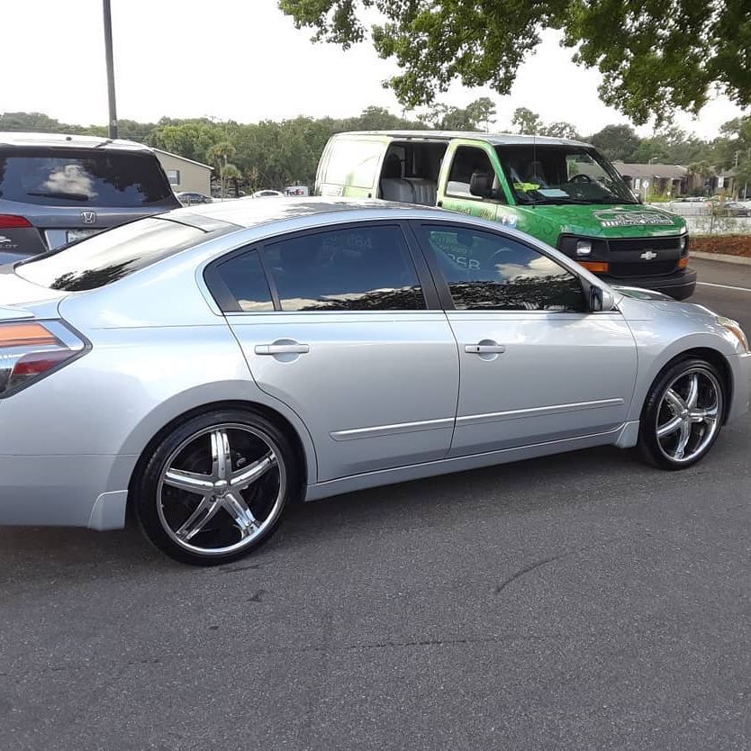 A silver car is parked next to a green van
