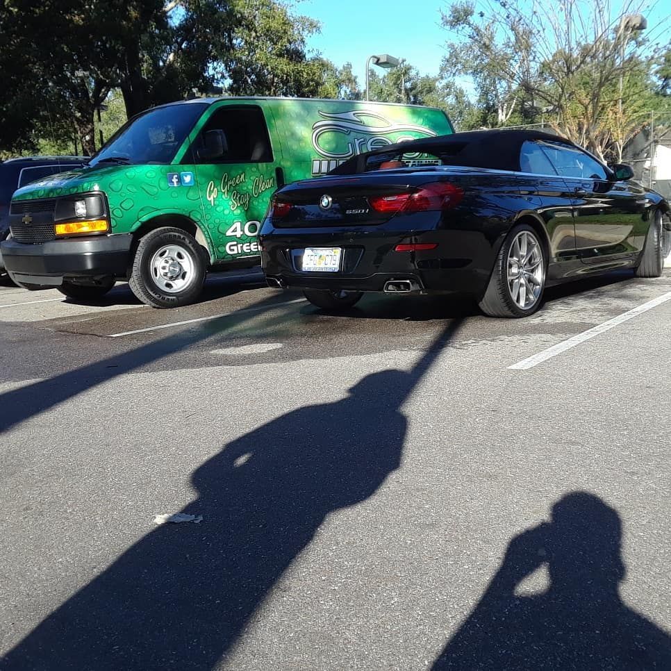 A black car is parked next to a green van