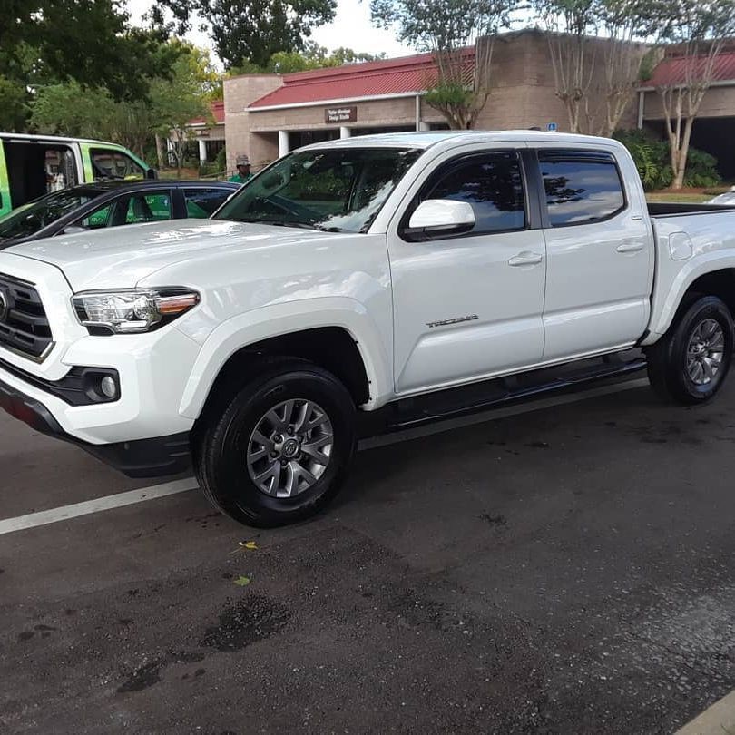 A white toyota tacoma truck is parked in a parking lot