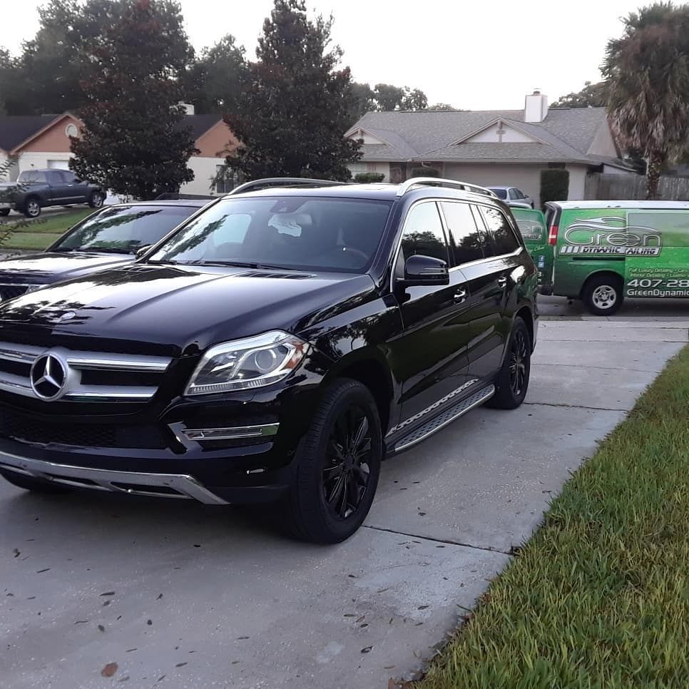 A black mercedes suv is parked in a driveway