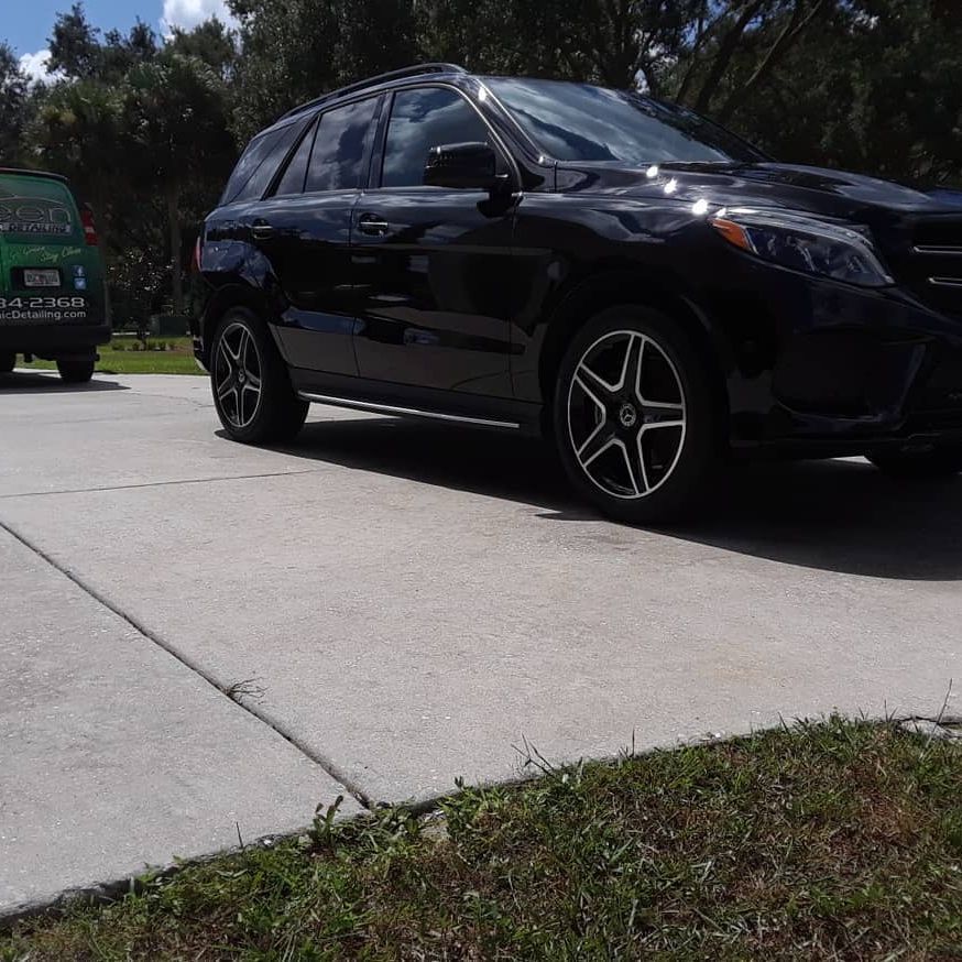 A black car is parked on the side of the road