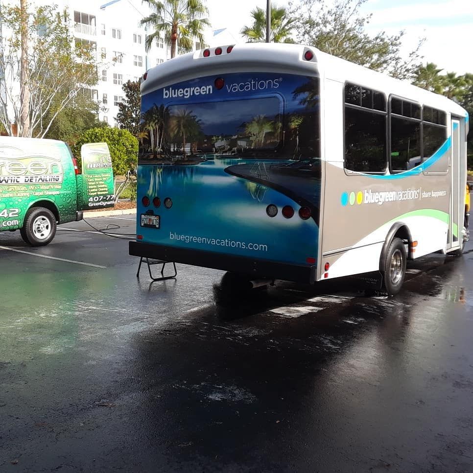 A bluegreen vacations bus is parked in a parking lot