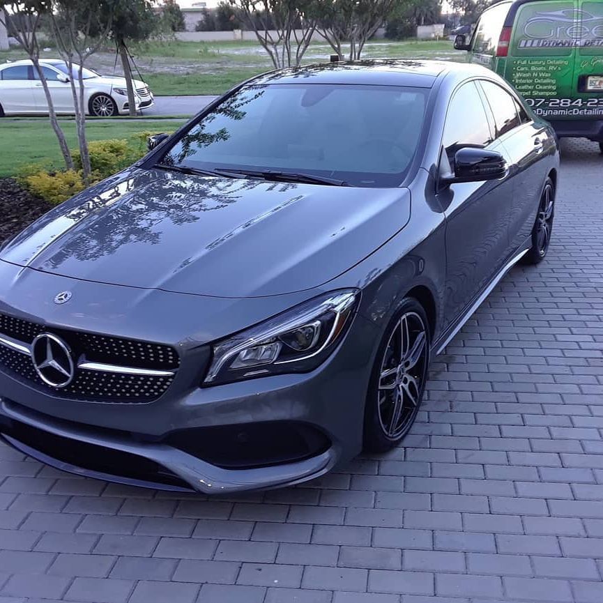 A mercedes benz cla 45 is parked on a brick driveway.