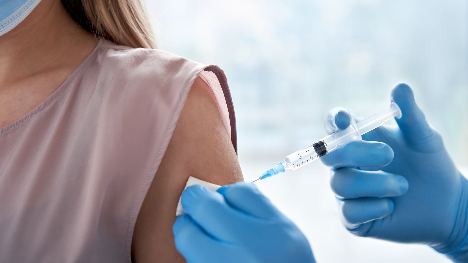 A woman is getting a vaccine in her arm.