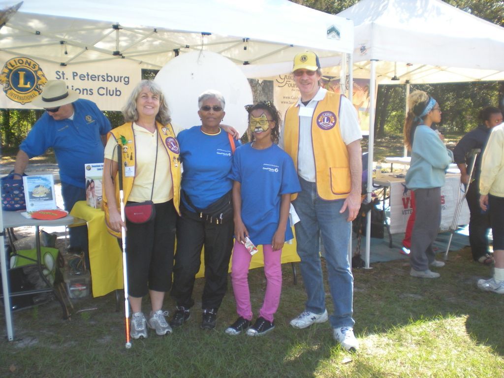 A group of people standing in front of a sign that says st petersburg lions club