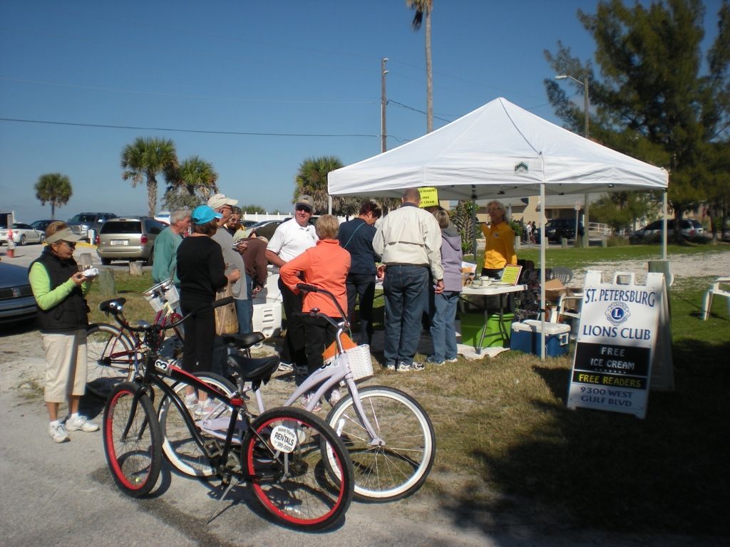 A group of people are gathered around bicycles under a white tent