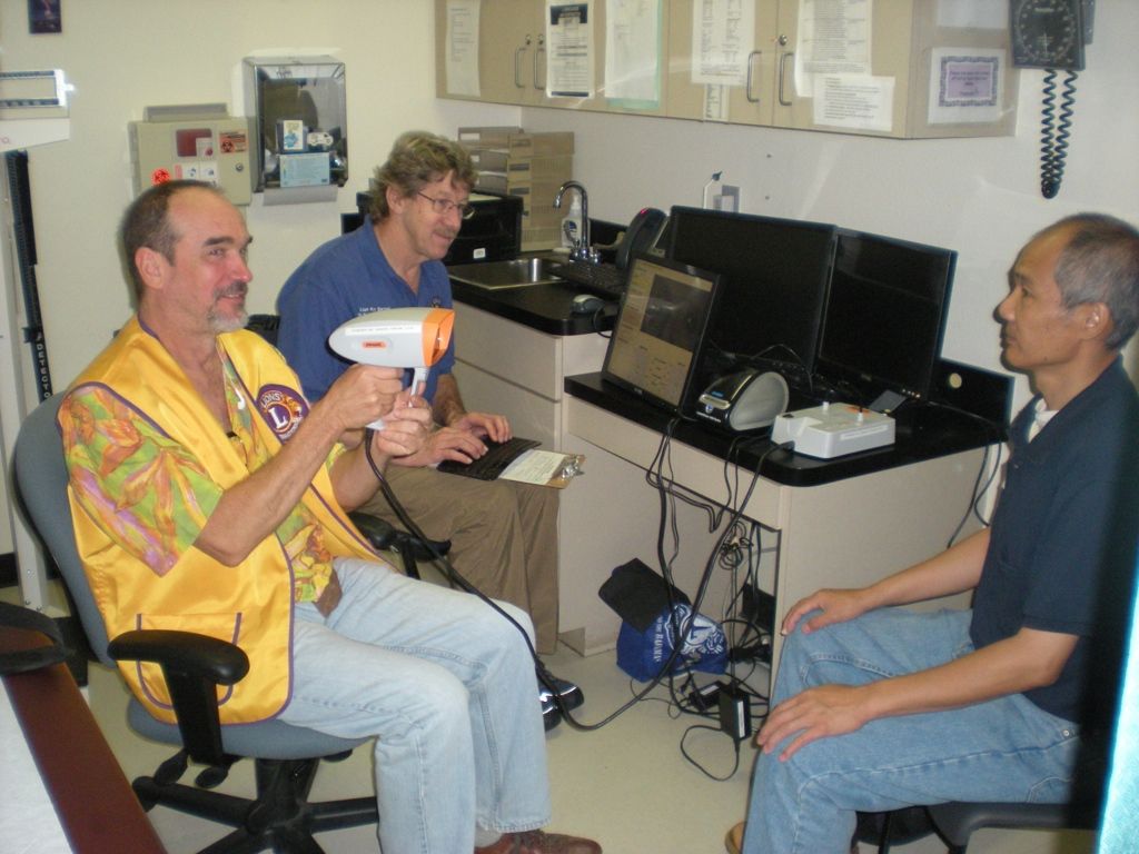 A man in a yellow vest is holding an orange object