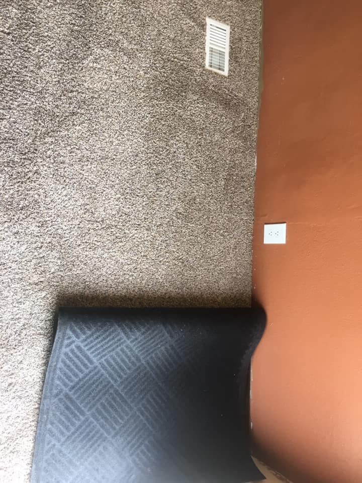 Person in green jacket working on a red semi-truck in a garage.