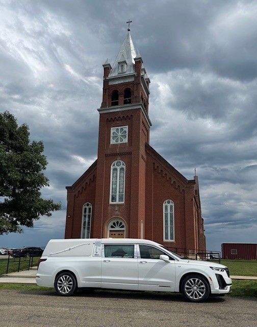 Grandparents and a child planting a flower together in a garden.