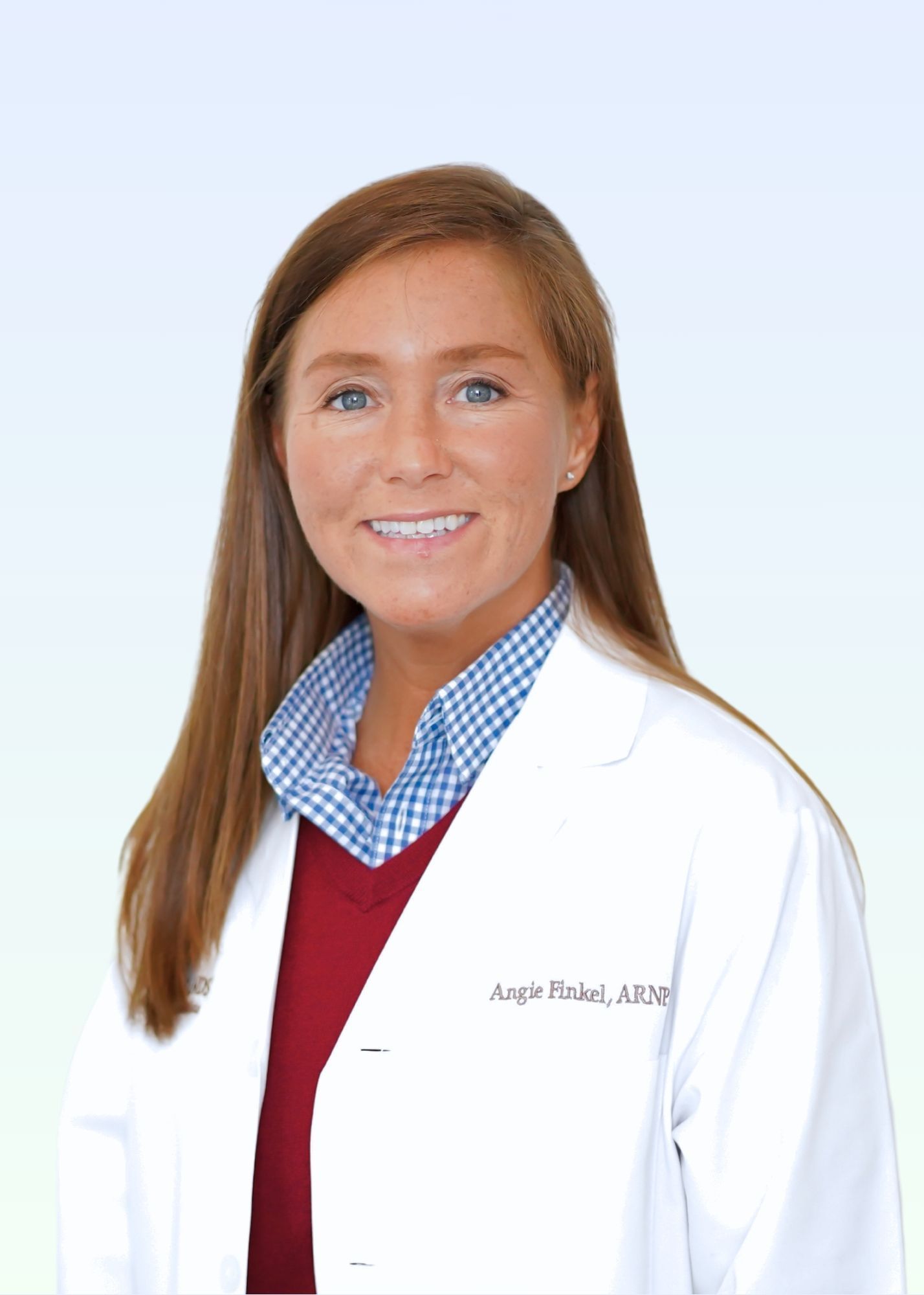 A woman in a white lab coat is smiling for the camera.