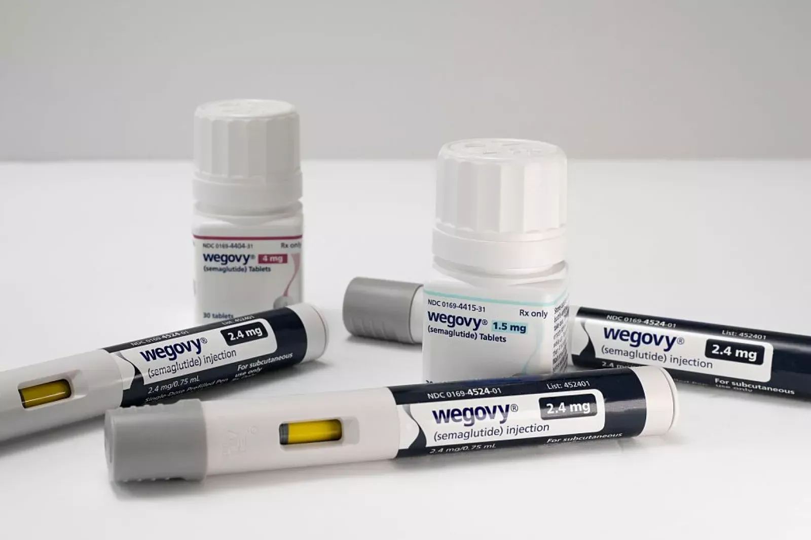 White Wegovy injection pens and labeled medication vials on a light surface.