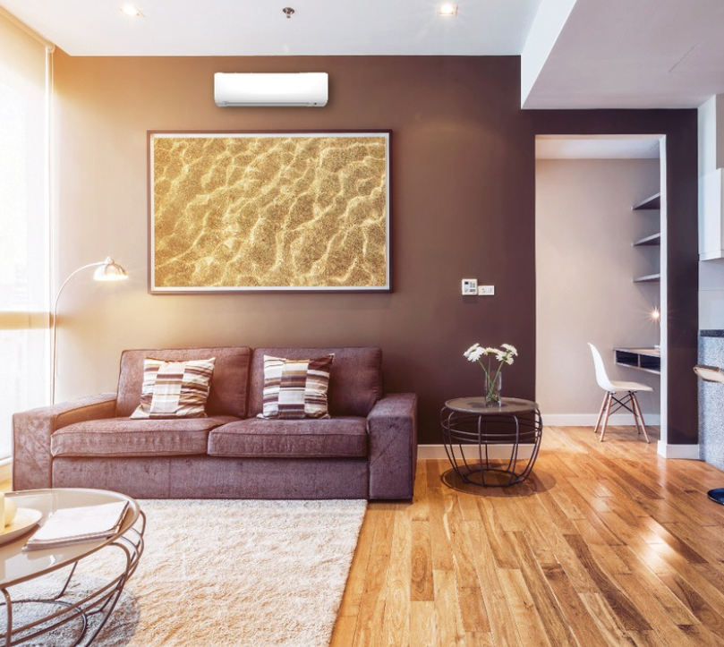 Living room with purple couch, artwork, and hardwood floors.