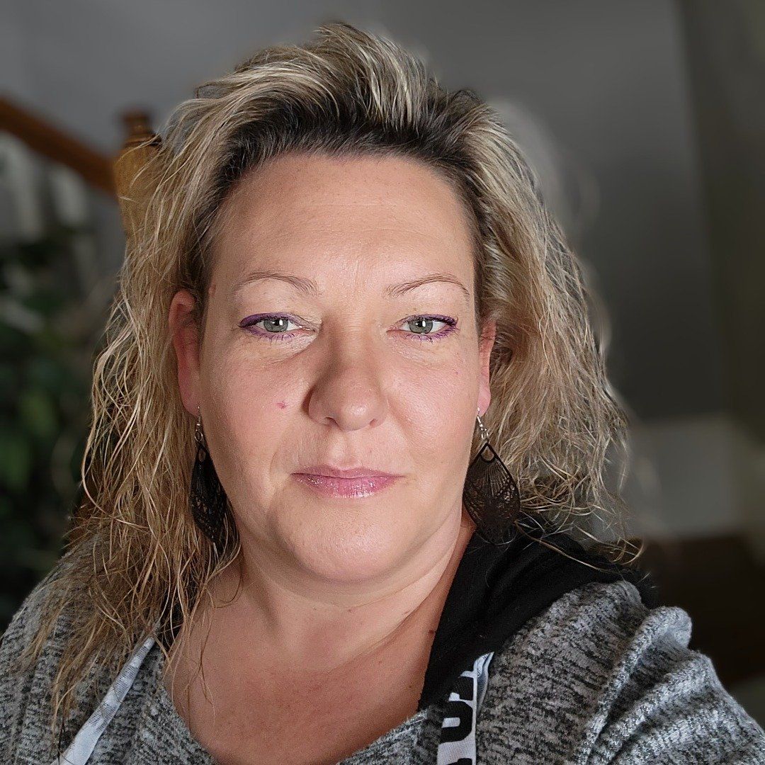 Woman in yellow beret and sweater, looking through binoculars, orange background.