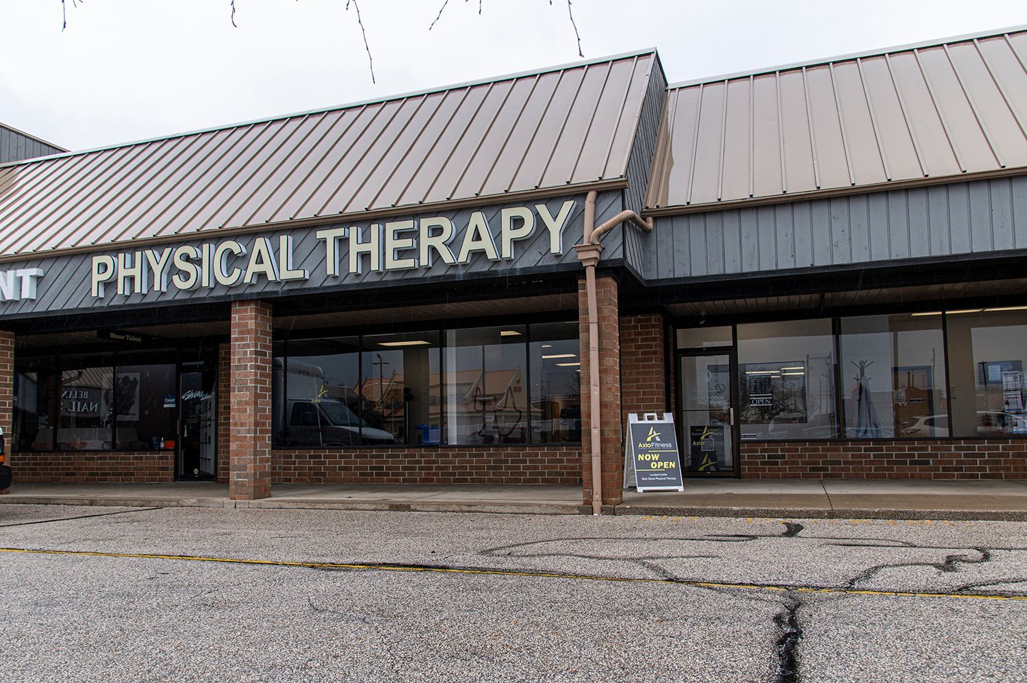 Exterior of a physical therapy clinic with a brown metal roof and large windows.