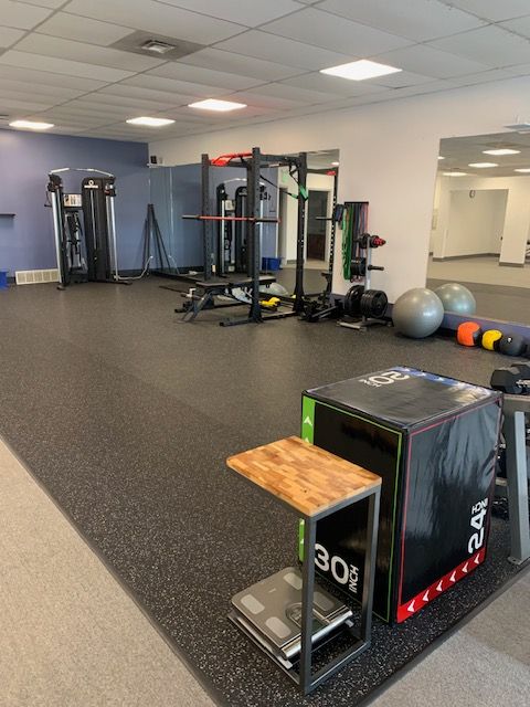 Gym interior with fitness equipment. Includes weight rack, plyo box, exercise balls, and weight machines.