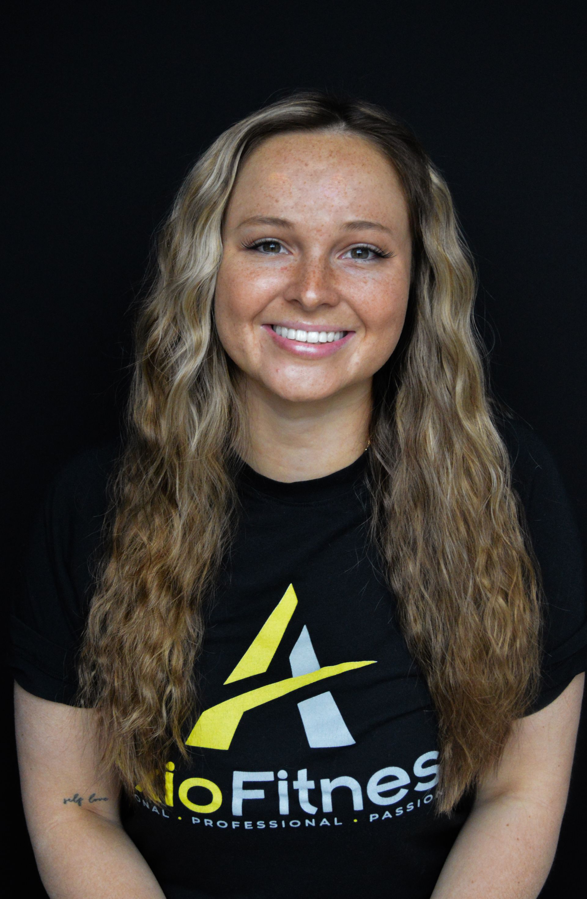 Woman with long blonde hair, smiling, wearing a black