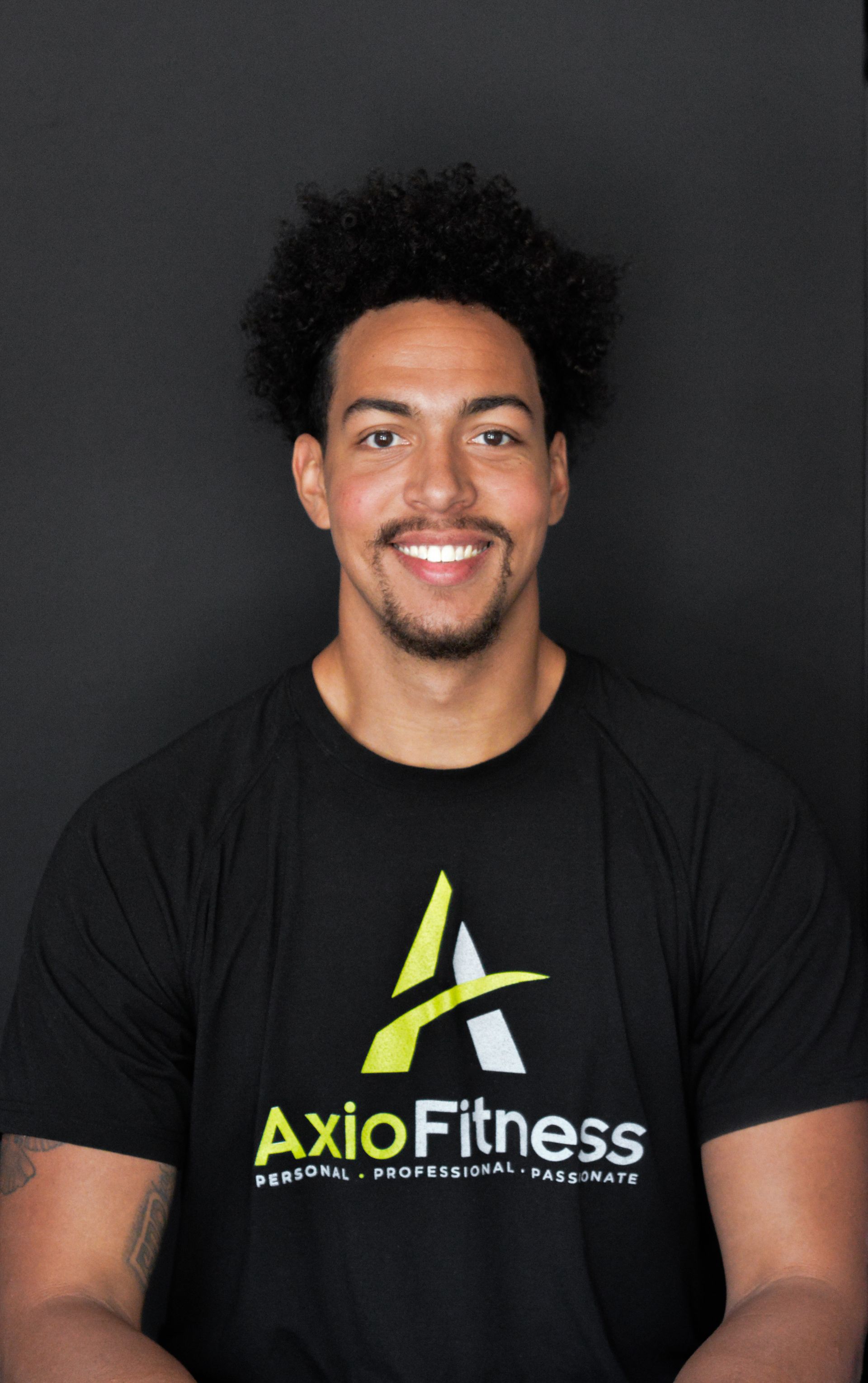 A smiling Black man wearing a black
