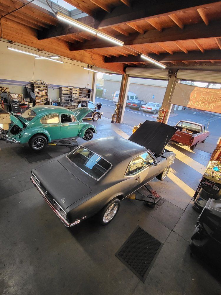 A car is sitting in a garage with its hood up.