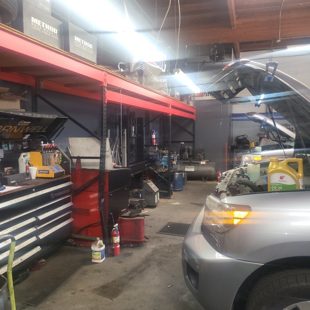 A car is parked in a garage with the hood up