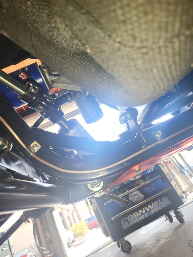 A close up of the underside of a car in a garage.