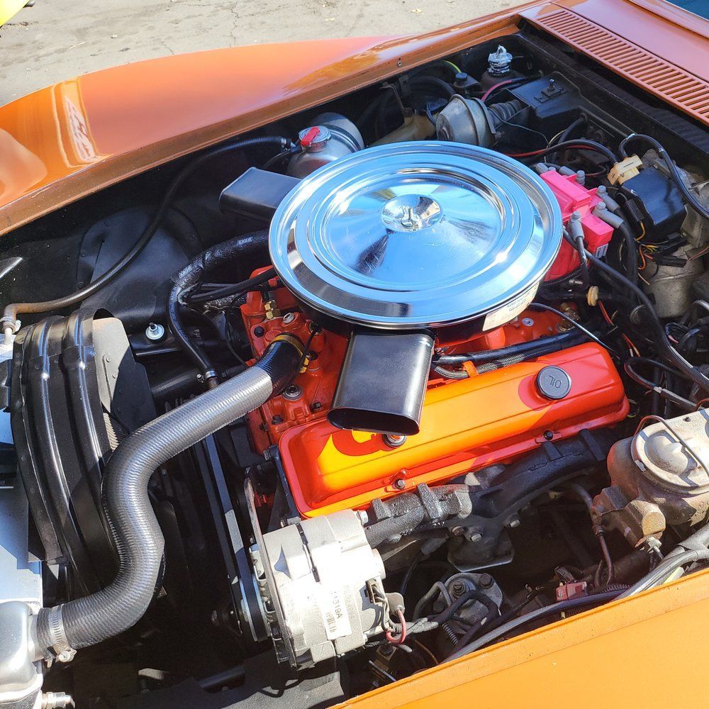 A close up of a car engine with a chrome air filter
